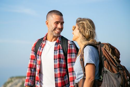 Free Smiling couple of backpackers enjoying a sunny day outdoors in Portugal. Stock Photo
