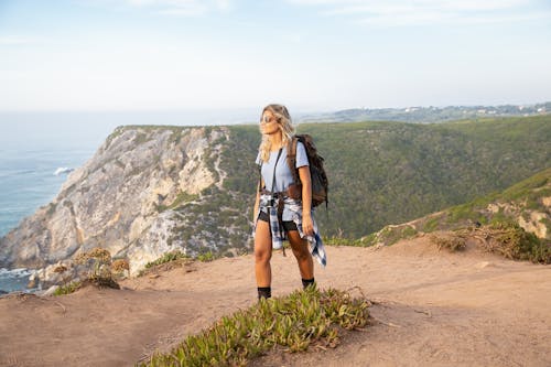 Free A Woman Carrying Backpack Standing while Looking Afar Stock Photo