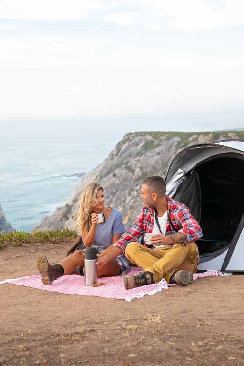 Free A couple enjoys a scenic camping trip on a cliff by the Portuguese coast. Stock Photo