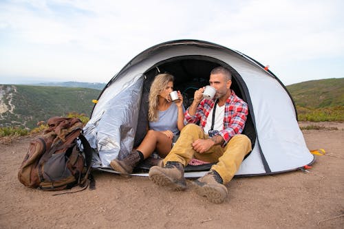 免费 黄色外套和蓝色牛仔短裤坐在棕色和白色帐篷上的女人 素材图片