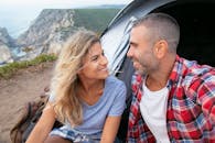 幸福的情侣在葡萄牙的悬崖边露营，微笑着享受大自然