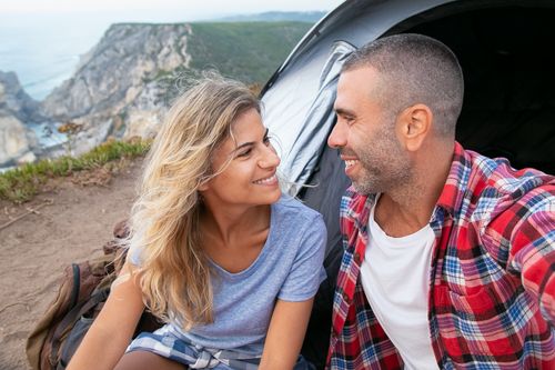 Free Happy couple camping by cliffs in Portugal, smiling and enjoying nature. Stock Photo