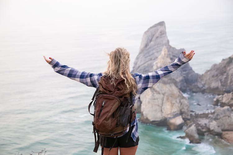 Blonde Girl With Backpack Welcoming View Of Sea