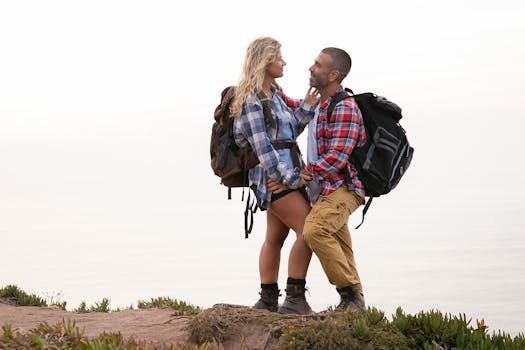 A couple embraces on a cliffside hiking trail in Portugal, enjoying the beautiful outdoors.