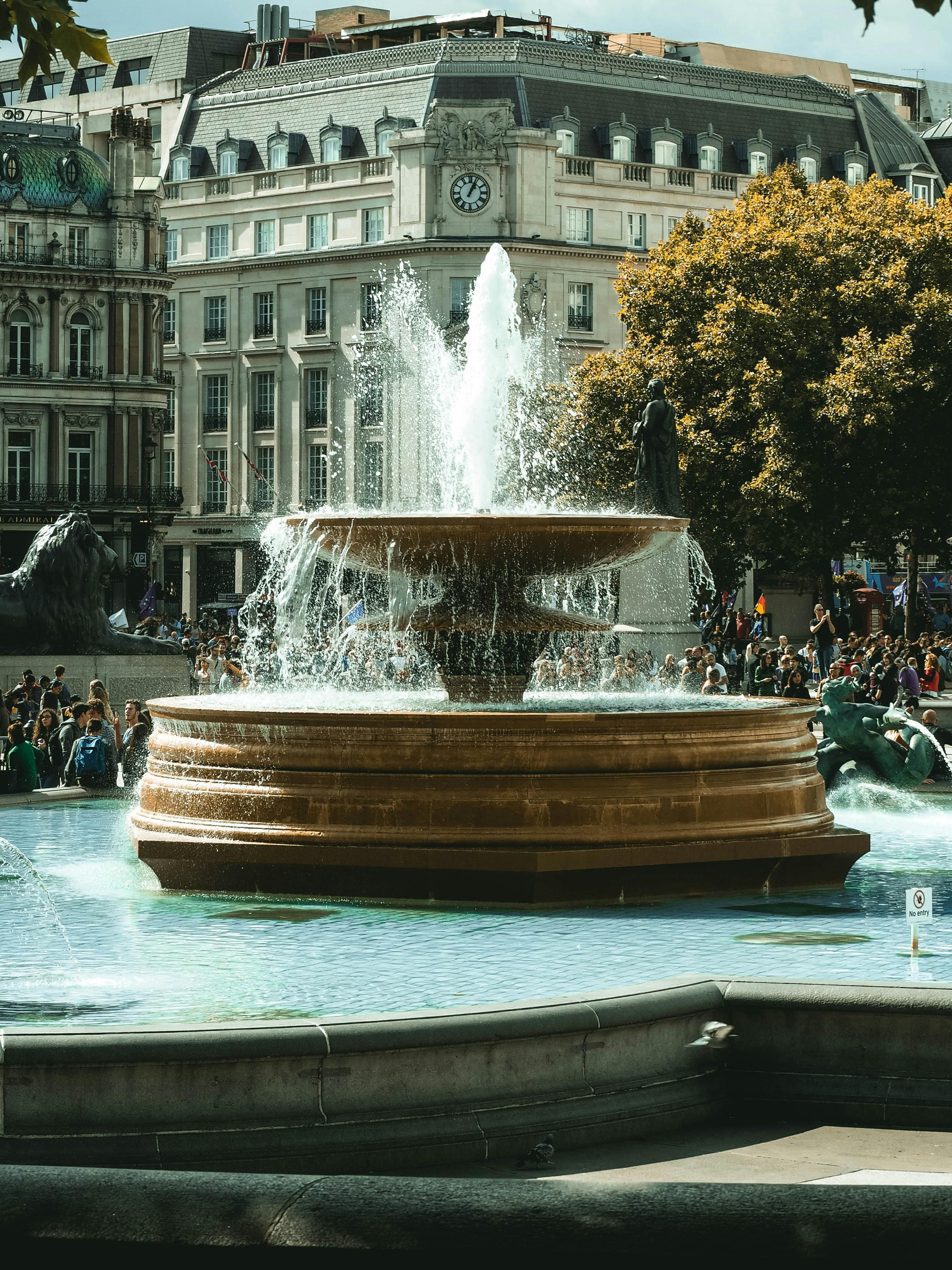 Iconic Trafalgar Square fountain surrounded by historic architecture in London.