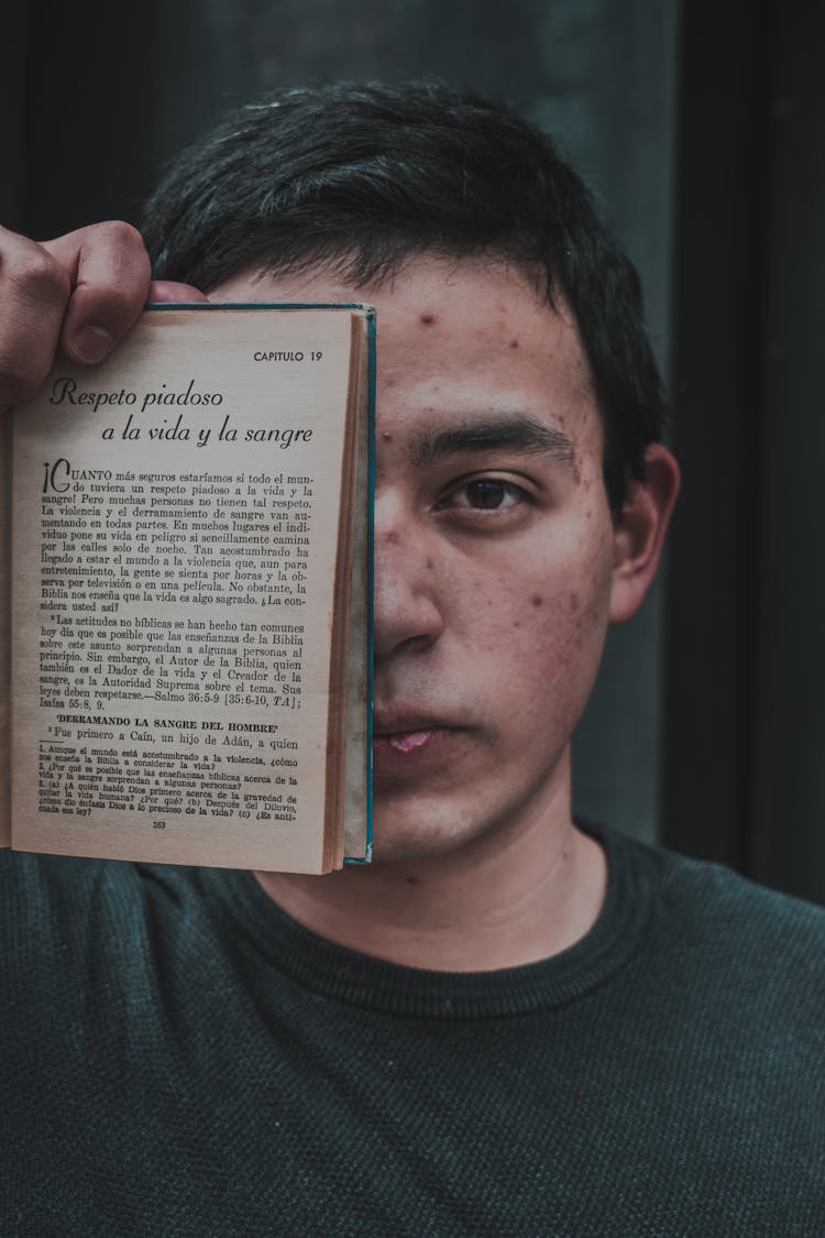 Man Covering Face With Book