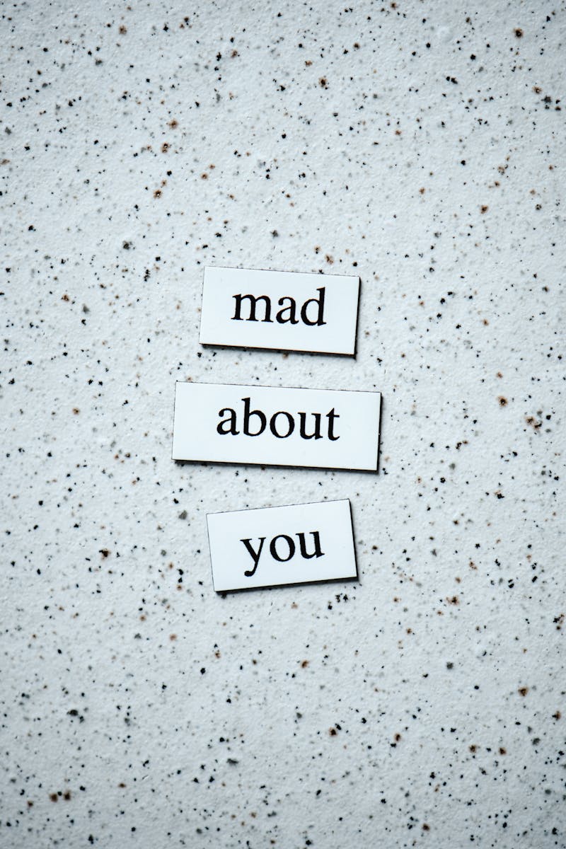 Artistic arrangement of the words 'mad about you' on a speckled surface.