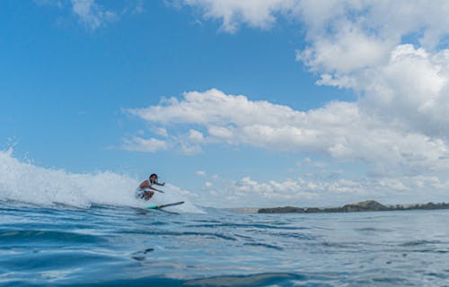 Man Surfing on Sea Waves Under Blue Sky