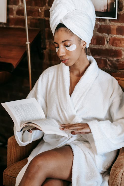 Ethnic woman reading book in spa salon