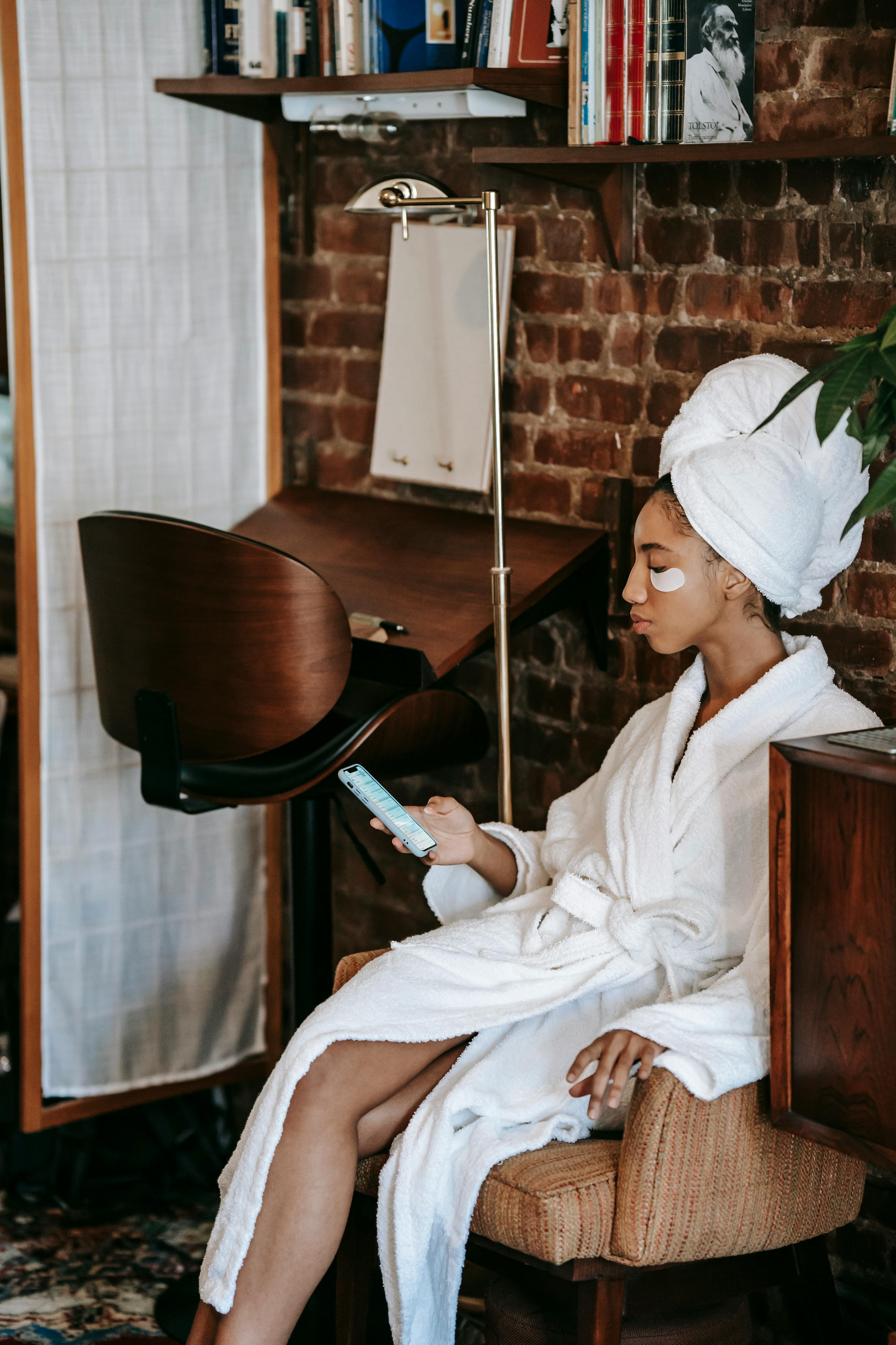 ethnic woman chatting on smartphone during procedure at home