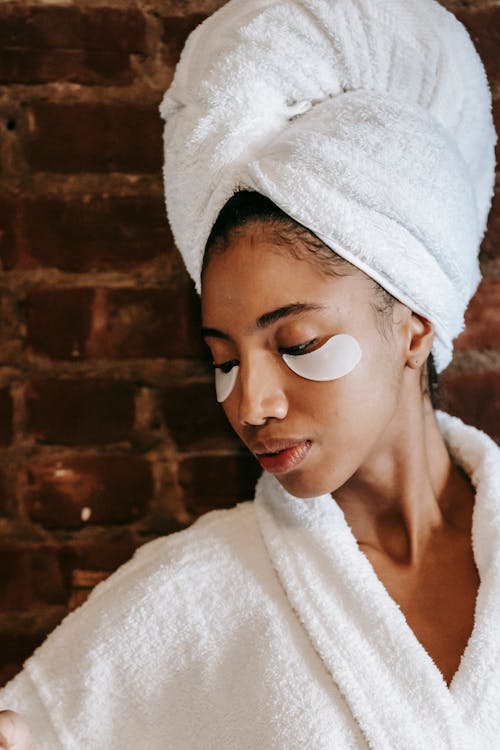 Charming ethnic woman with eye patches in beauty salon