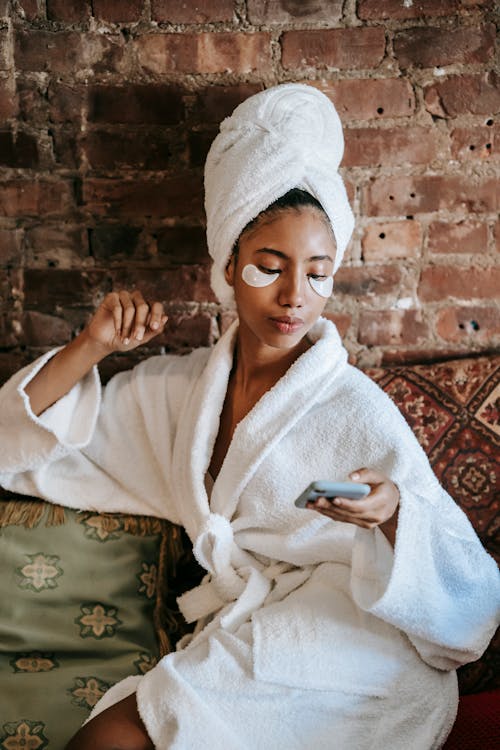 Feminine ethnic woman chatting on smartphone in beauty salon