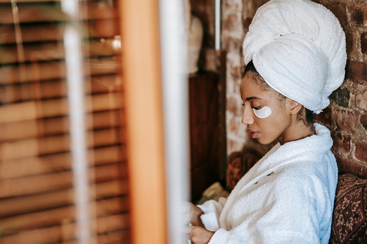 Charming Ethnic Woman In Towel And Robe In Spa Center