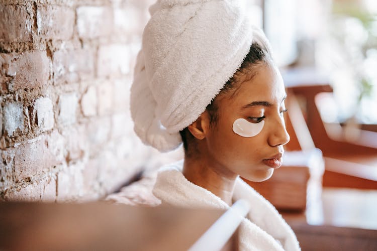 Ethnic Woman With Eye Patches In Shiny Spa Center