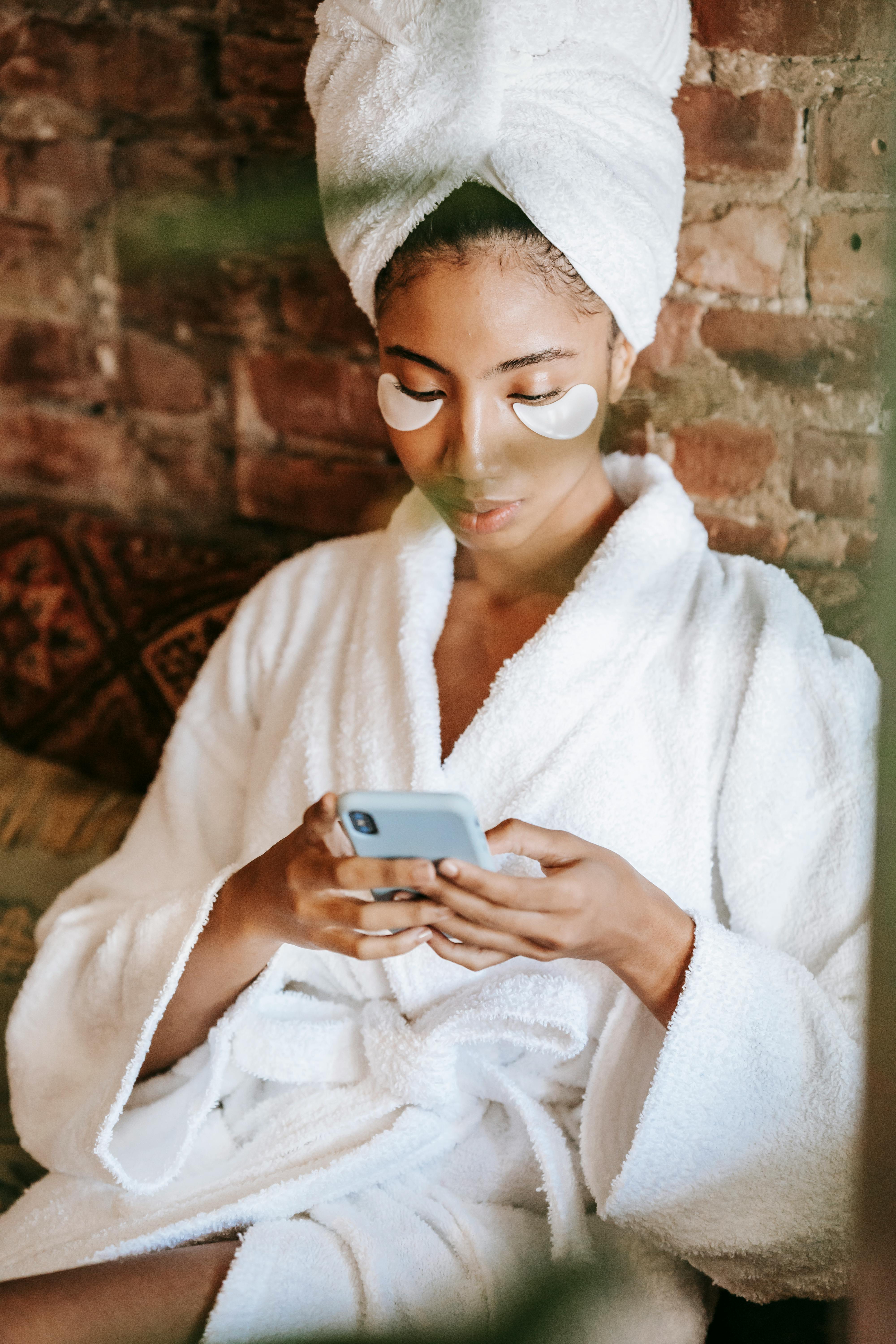 focused ethnic woman chatting on smartphone in spa center