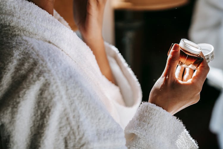 Crop Ethnic Woman Applying Nourishing Cream On Face At Home