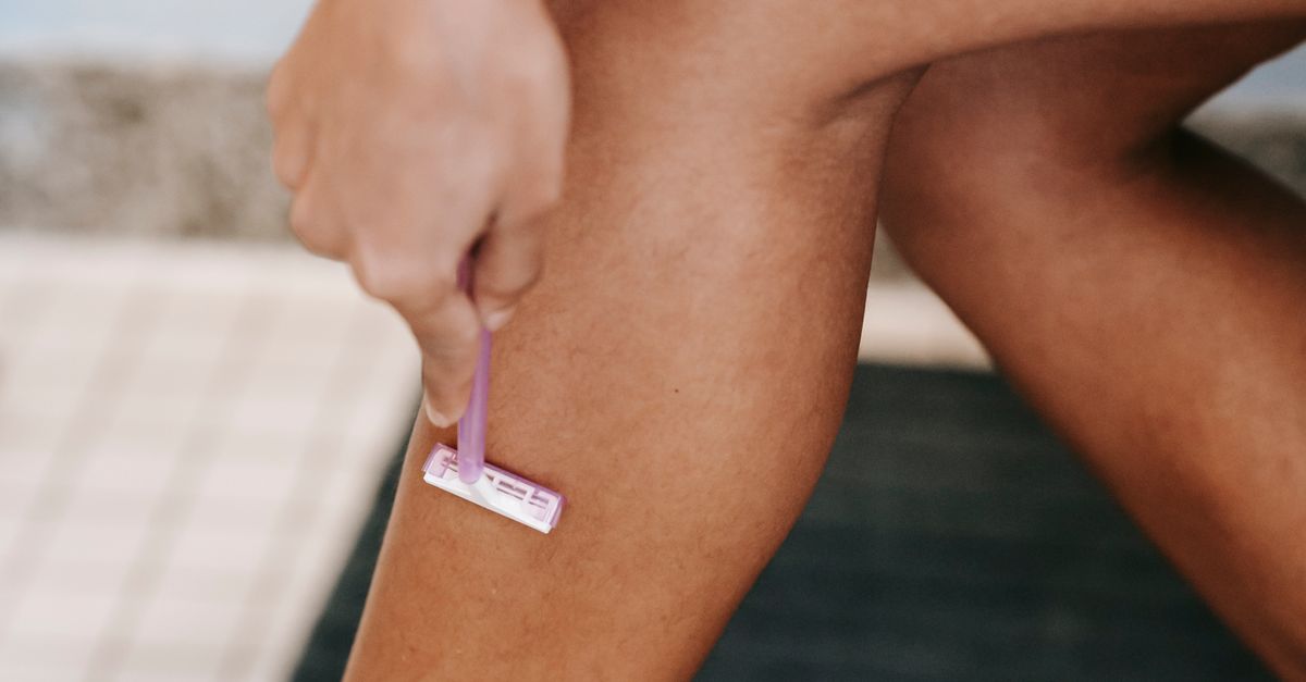 Ethnic woman shaving legs with razor in bathroom · Free Stock Photo