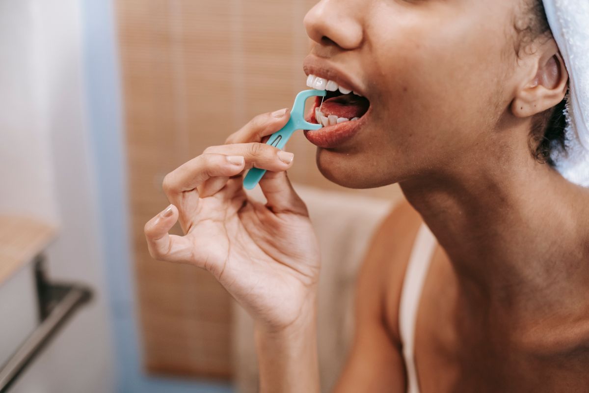 Close-up of a dental hygienist demonstrating proper flossing technique