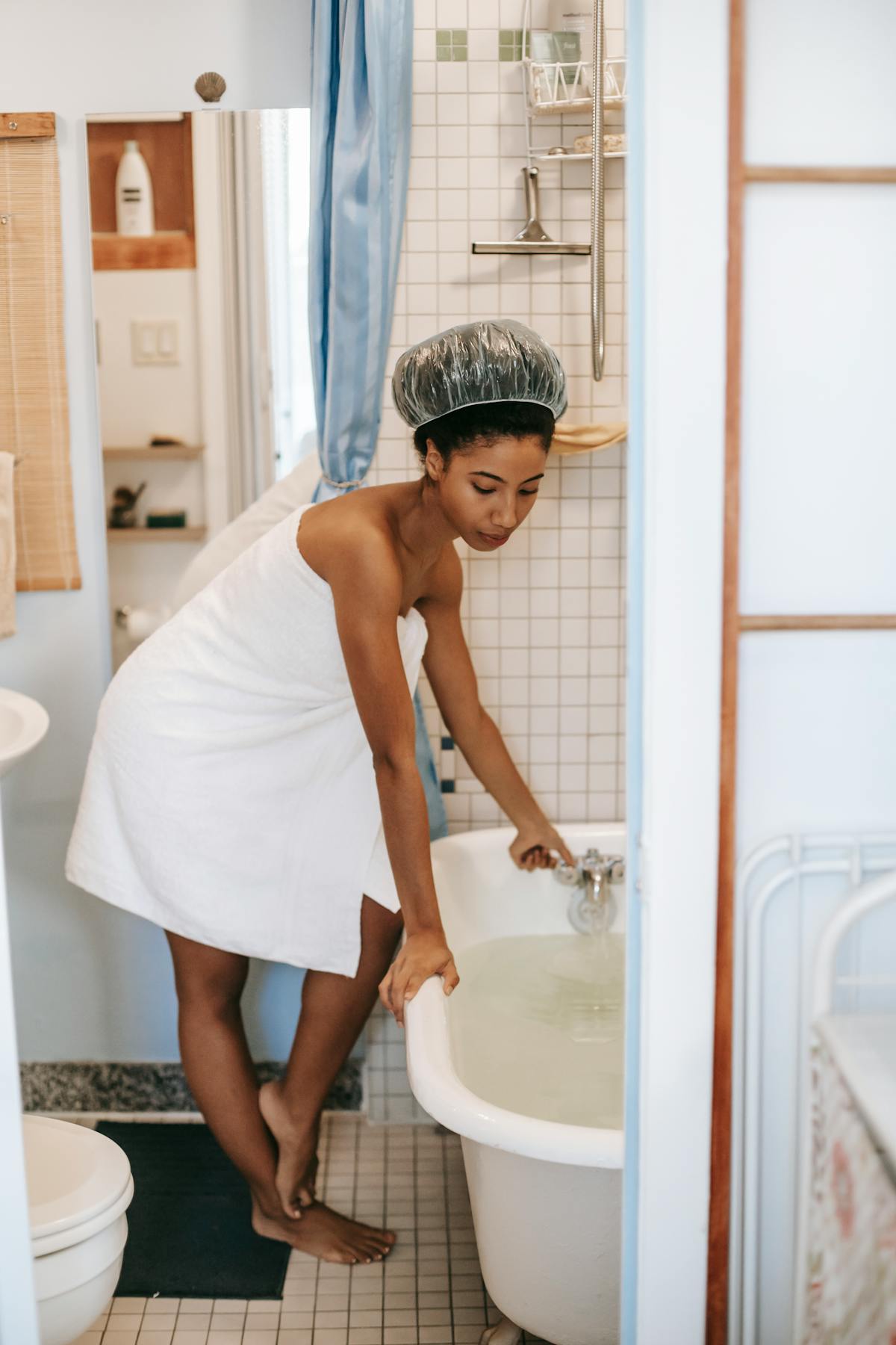 Blender with green smoothie mixture and ingredients on a countertop