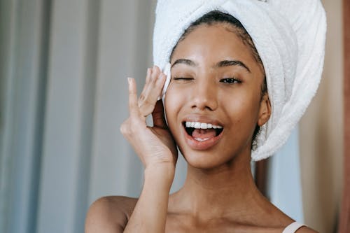 Happy ethnic woman wiping face