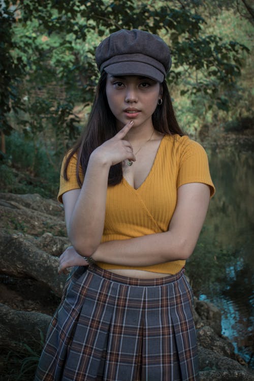 Woman in Yellow Shirt and Plaid Skirt Wearing Hat 