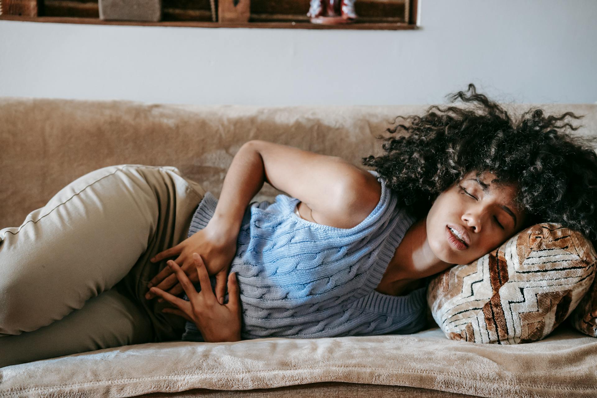 Woman Suffering from a Stomach Pain Lying Down on Couch