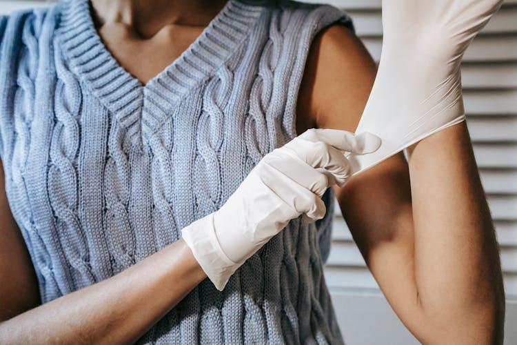 Unrecognizable Woman Putting On Rubber Gloves