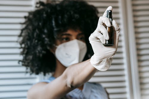 Woman spraying antiseptic in room