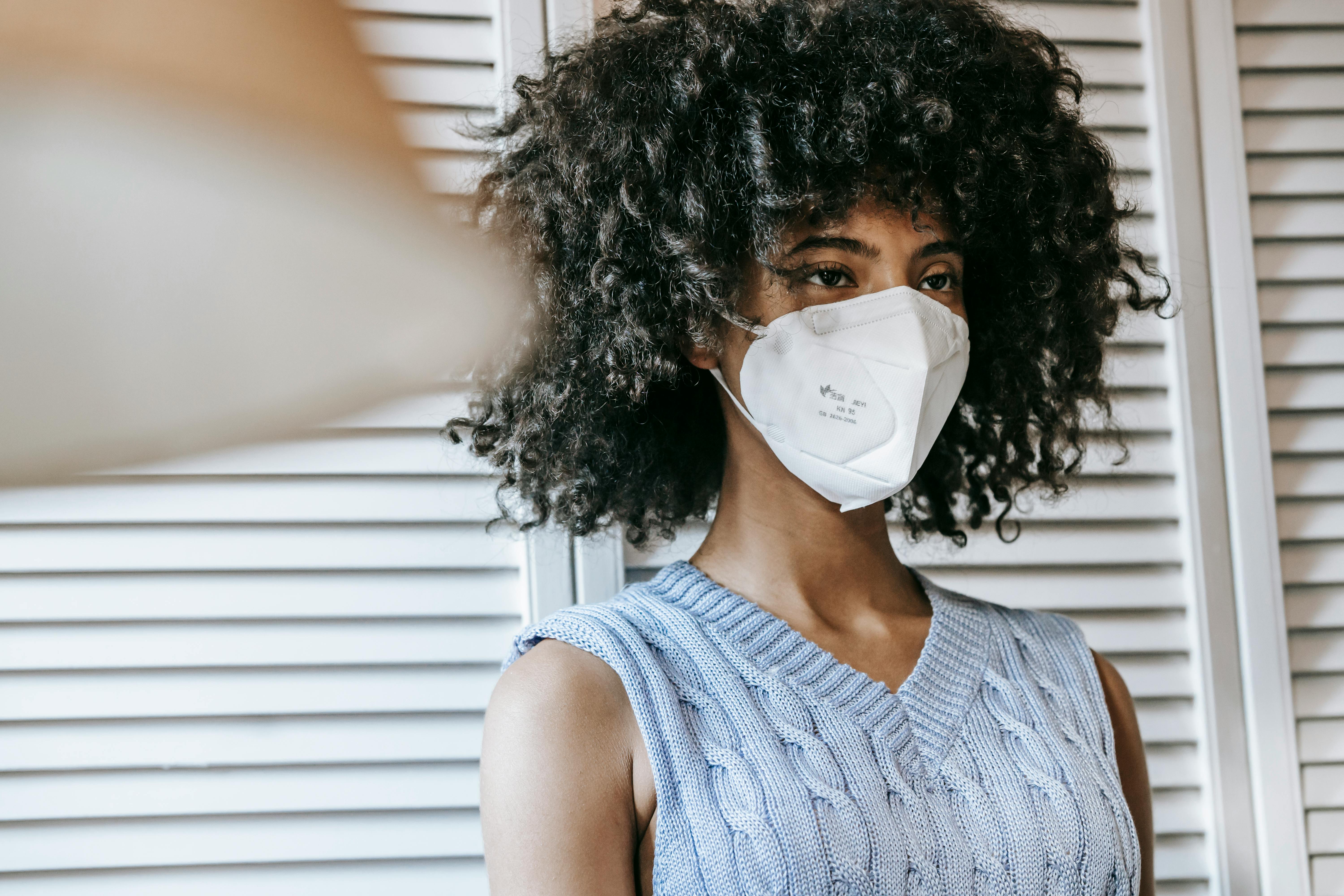 black woman in mask looking away