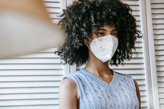Black woman in mask looking away