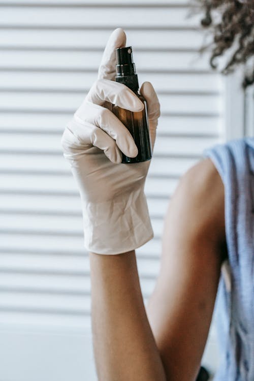 Crop woman with sanitizer in sprayer