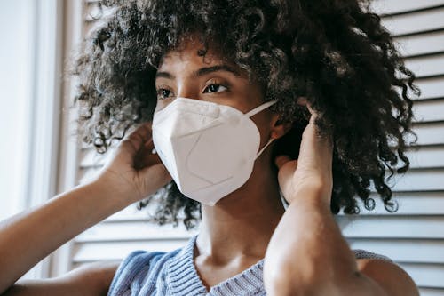 Black woman putting on respirator