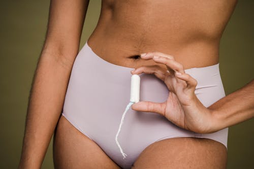 Woman in panties showing female tampon