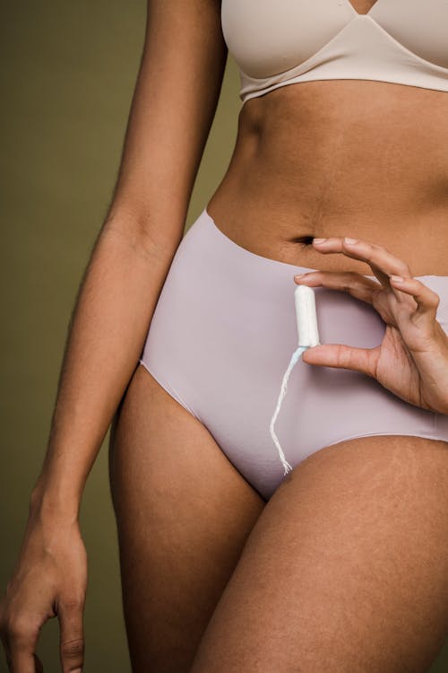 Woman in pink underwear with sanitary tampon