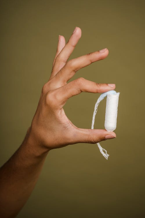 Woman showing female tampon in hand