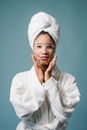 Black woman after spa applying sheet mask