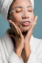 Black woman applying moisturizing sheet mask