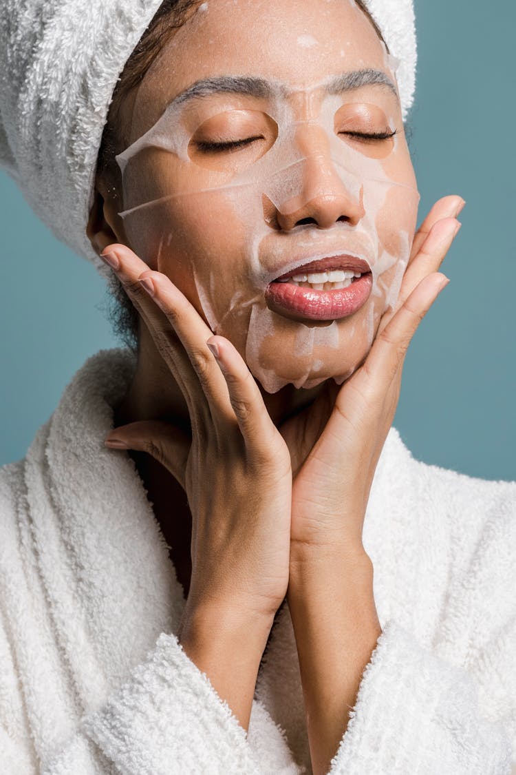 Black Woman Applying Moisturizing Sheet Mask