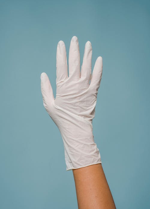Hand in medical glove against blue background