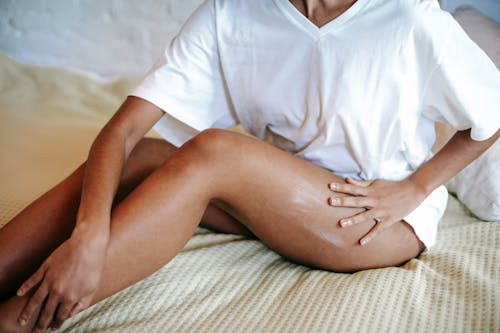 Woman massaging leg with cream