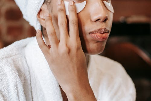 Free Woman applying eye patches on face Stock Photo