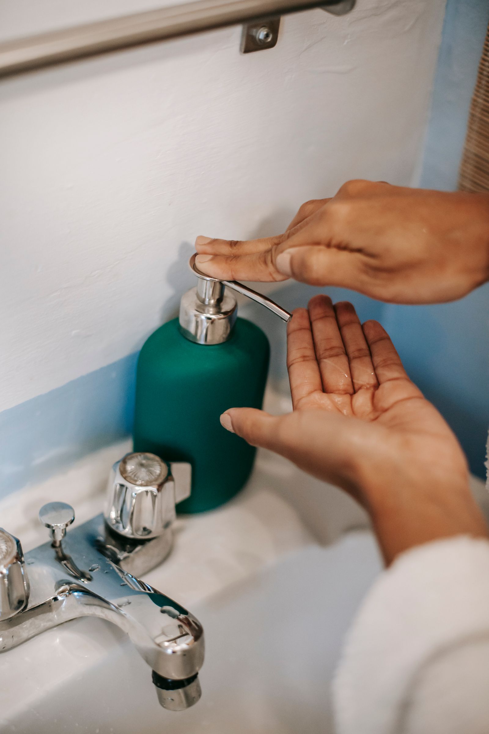 Close view of hands doing a careful home task with the thumb and wrist visible