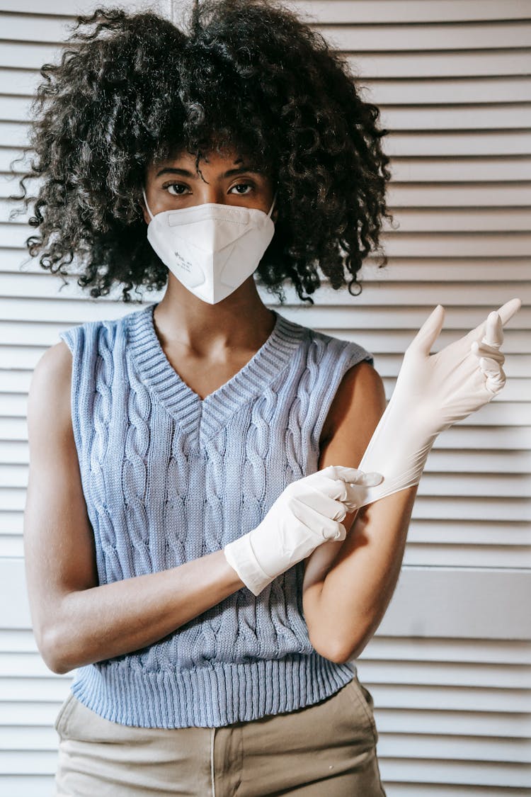 Ethnic Woman Putting On Gloves During Coronavirus Pandemic