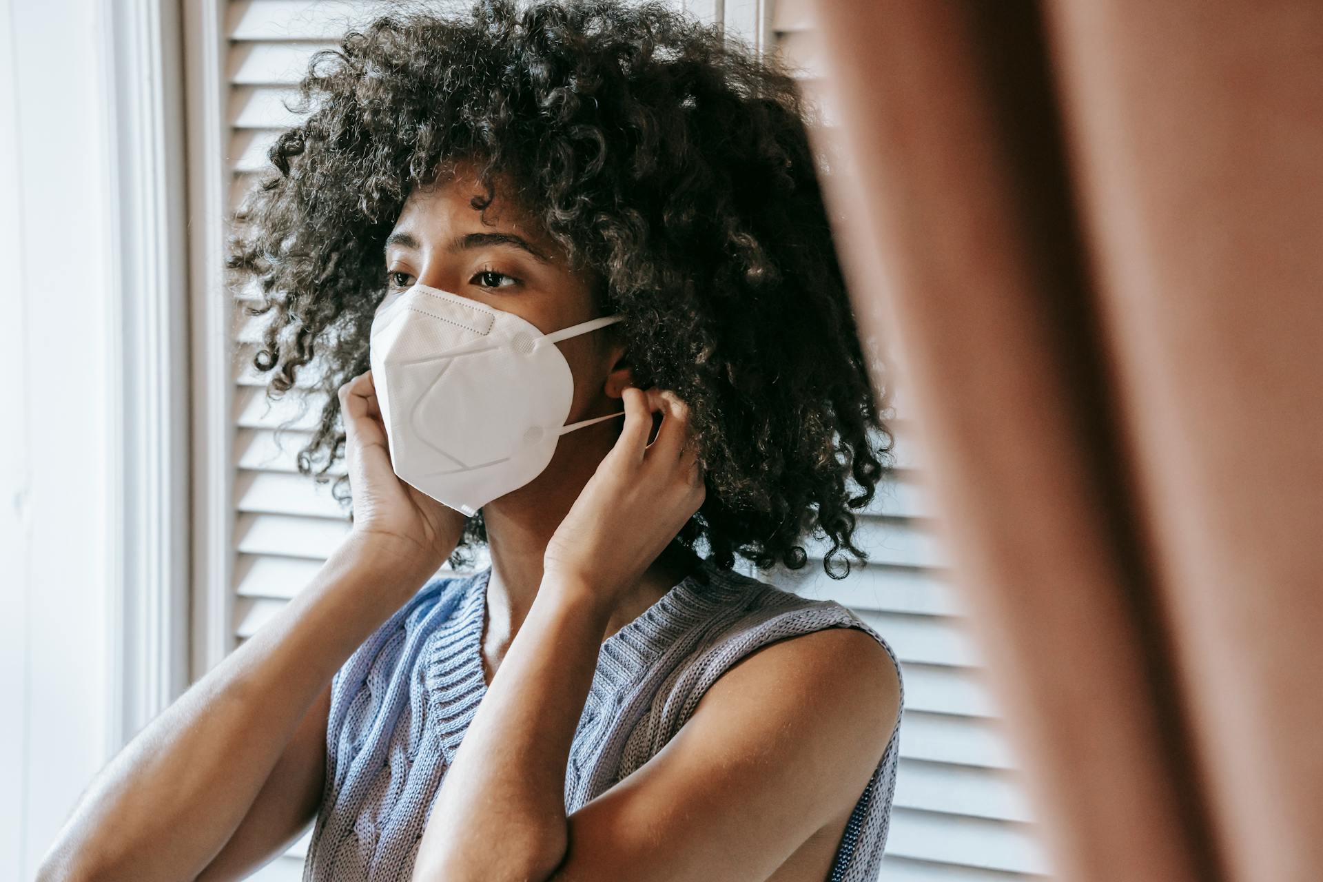 Ethnic woman putting on protective mask