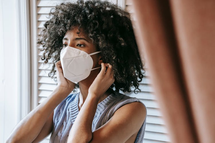 Ethnic Woman Putting On Protective Mask