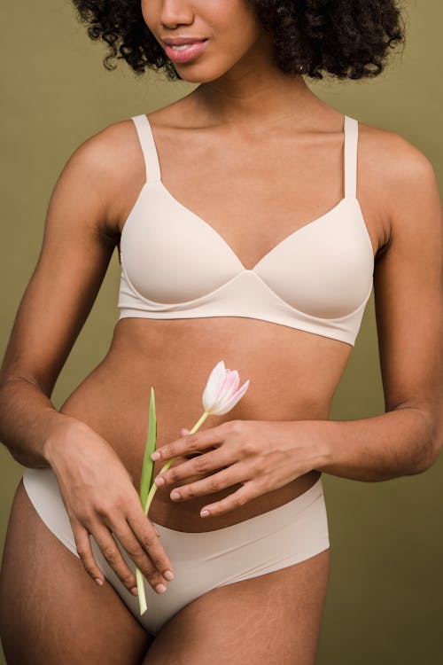 Ethnic female in underwear with blooming flower