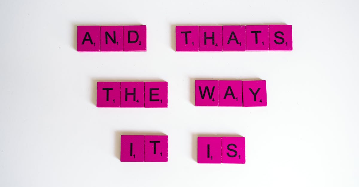 Inspirational quote 'And That's The Way It Is' on pink Scrabble tiles.