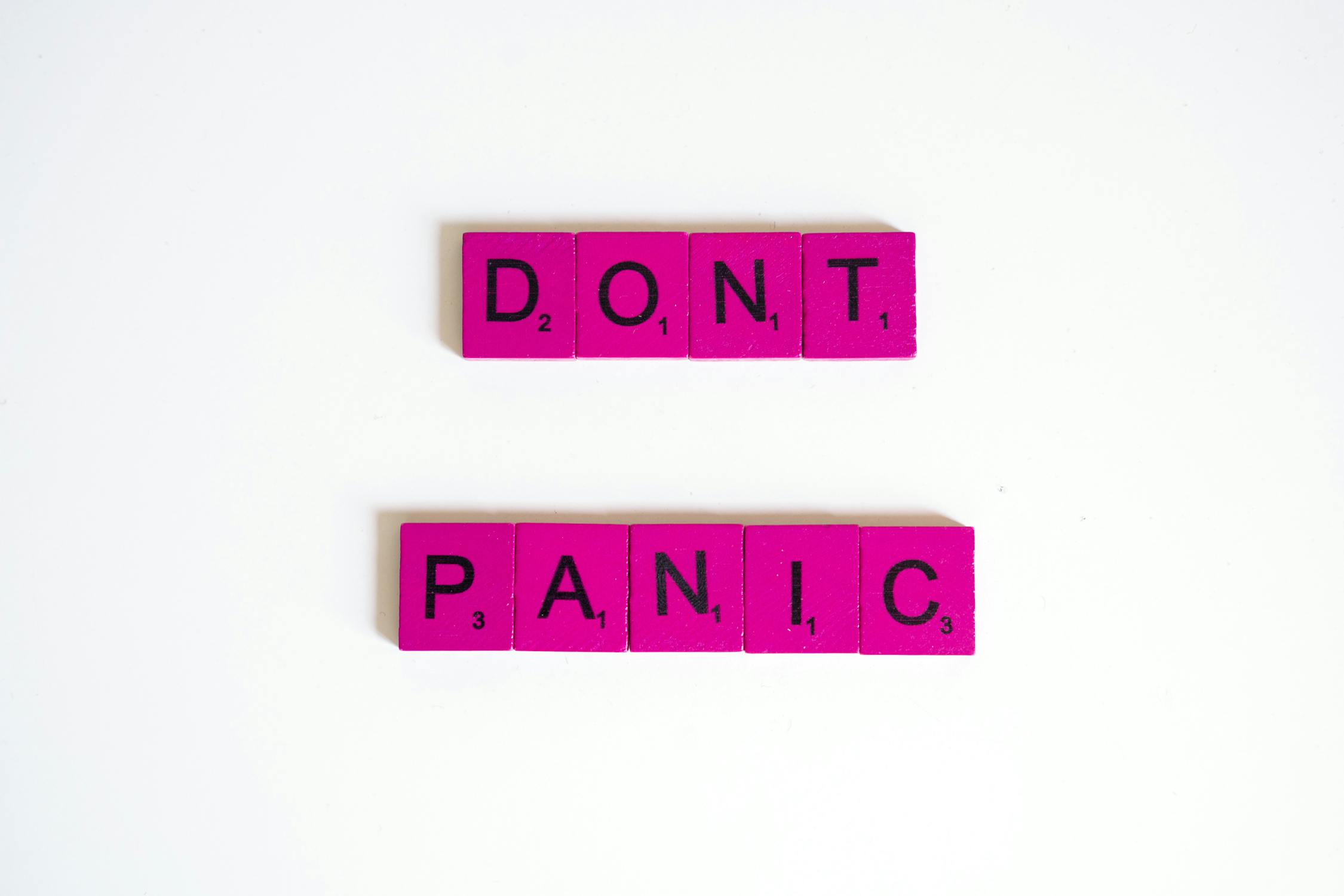 pink scrabble tiles spelling out the phrase 'Don't panic'
