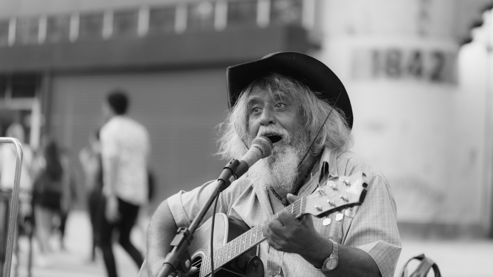 Black and white photo of an elderly street musician singing and playing guitar. Black and white photo of an elderly street musician singing and playing guitar.