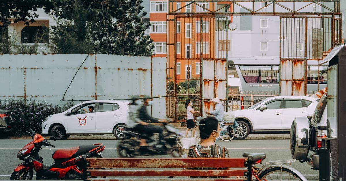 Captivating urban scene in Vũng Tàu, Vietnam, featuring a woman on a bench and busy street activity.
